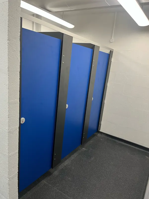 Washroom after: new blue cubicles with dark grey pilasters