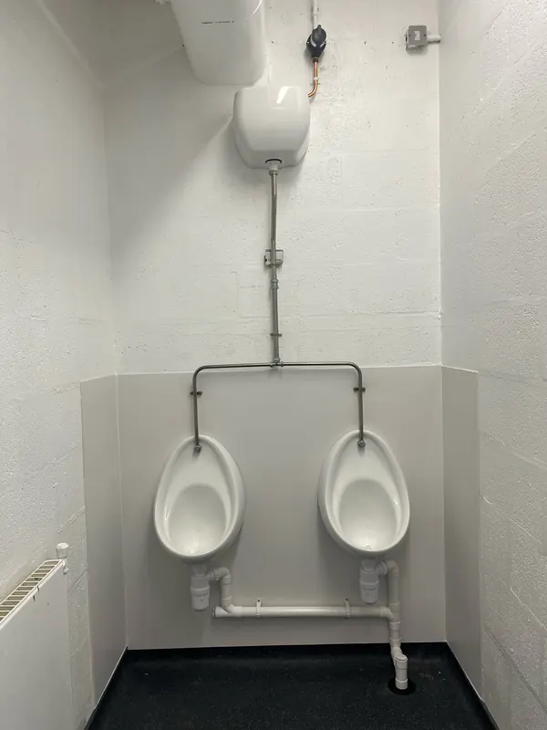 Washroom after: bowl urinals on a grey panel